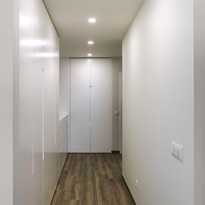 Corredor com roupeiros em lacado branco com puxador recavado